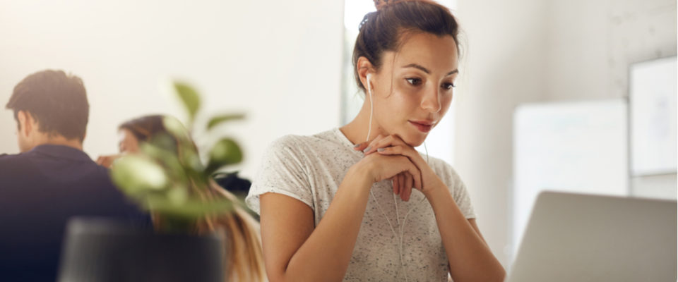 Photo of woman in bright coworking space working to fix HTML on laptop. how to fix wordpress formatting and alignment issues