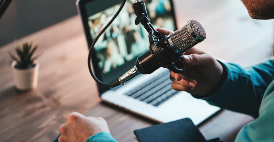 Podcast microphone in front of a laptop screen