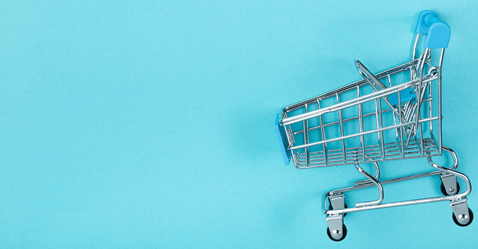 Integrate BigCommerce plugin with WordPress. Image depicts a miniature shopping cart on a light blue background