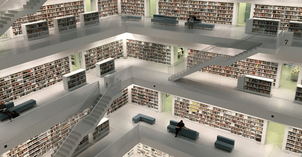 Modern all white library filled with books and staircases