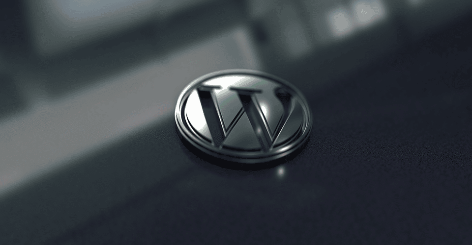 a metallic version of the WordPress logo on a glassy surface