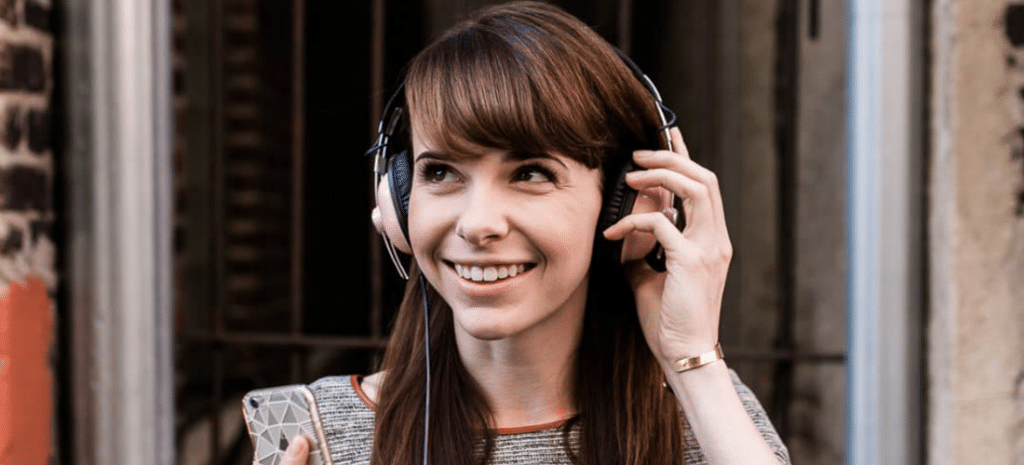 a creative smiles while removing her over-the-ear headphones