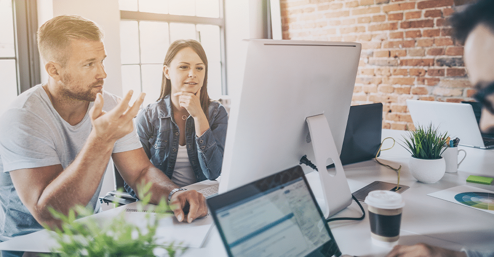 Web designers looking at computer screen inside agency office