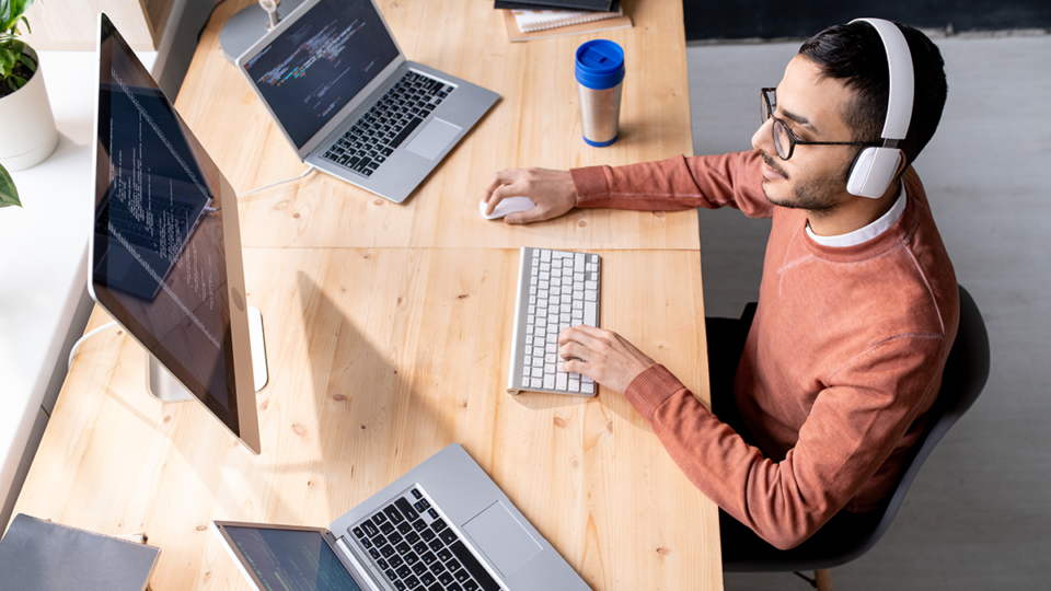 a developer prepares to learn WordPress at a desk with a laptop and a second monitor