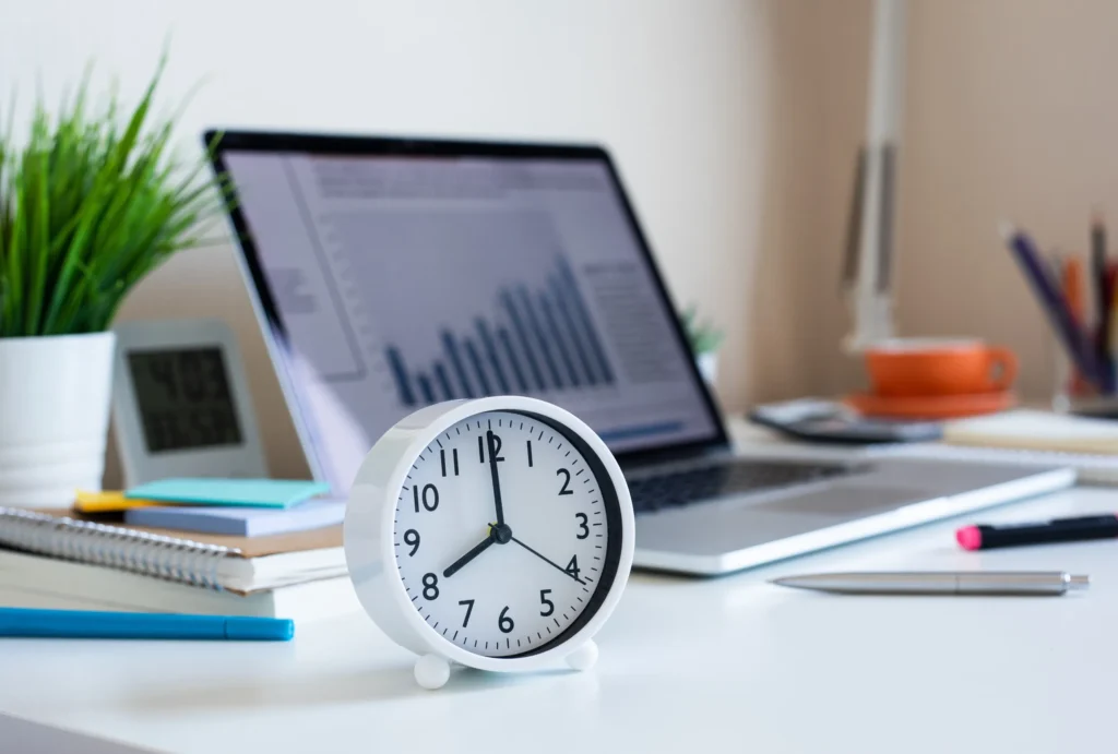 An agency tries to maximize billable hours by keeping an analog clock next to the laptop on their desk.